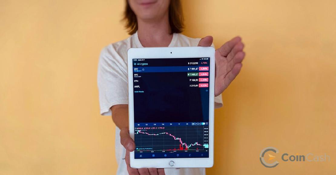 Fiatal férfi tart egy ipadet, amin a HODL app van megnyitva.